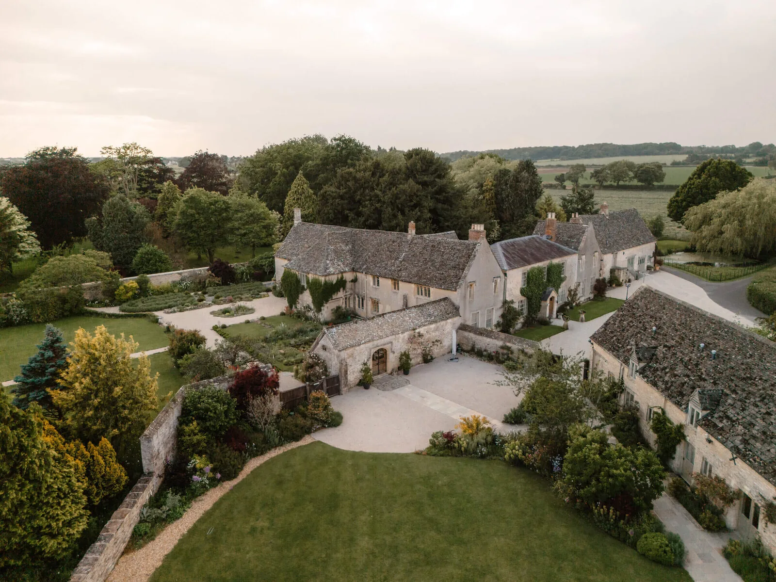 Caswell House — a historic Cotswolds barn and estate bathed in late afternoon light
